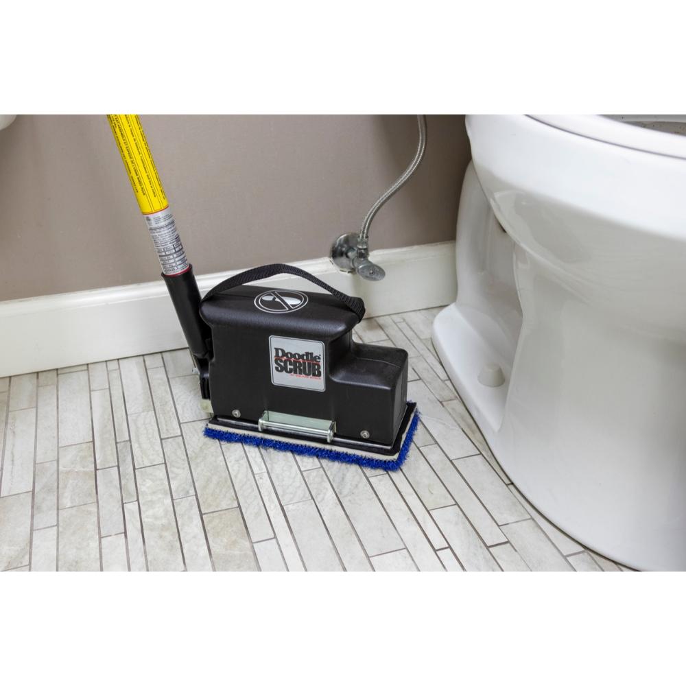 Floor cleaning tool being used on a bathroom floor next to a toilet.