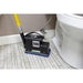 Floor cleaning tool being used on a bathroom floor next to a toilet.