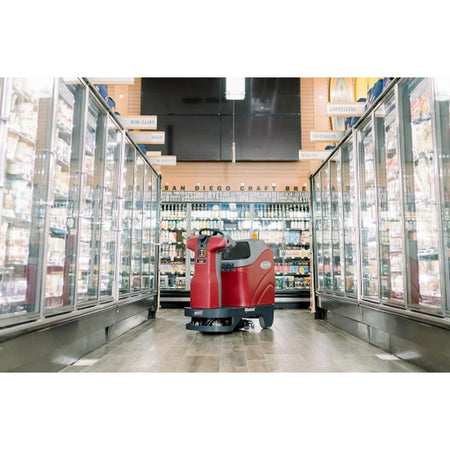 Minute man Autonomus RoboScrub in the middle of the well-lit freezer isle of a grocery store.