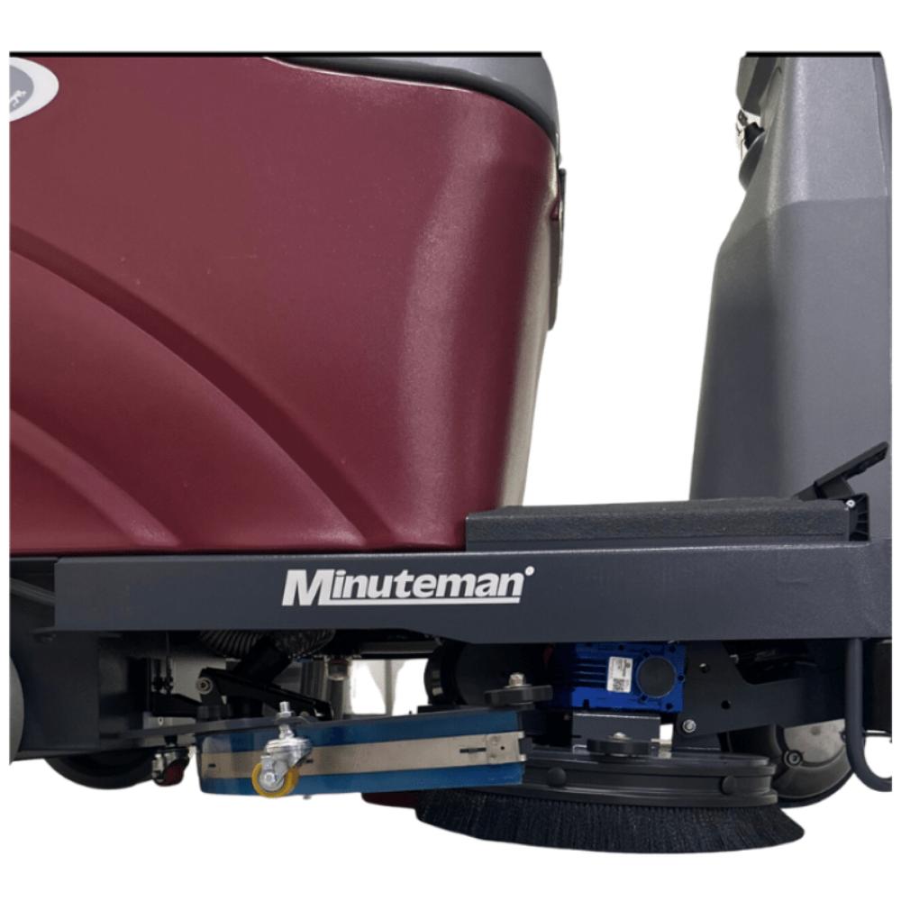 Black underside Sweeper attachment on minute man max ride 26 riding floor scrubber 