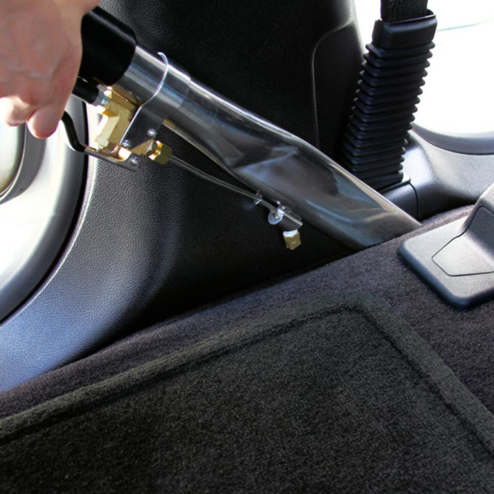 Car interior with a hand using a tool to remove a panel.