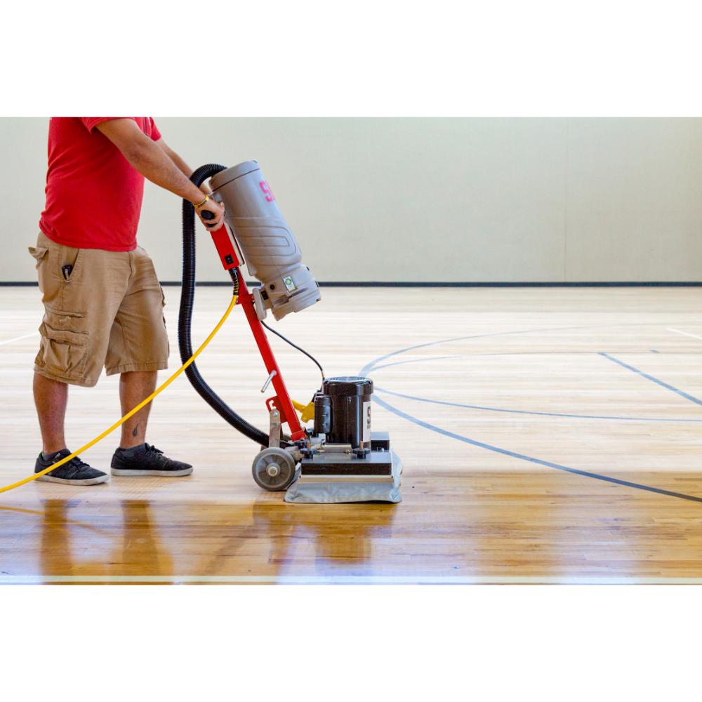 Person using a floor polisher on a wooden floor