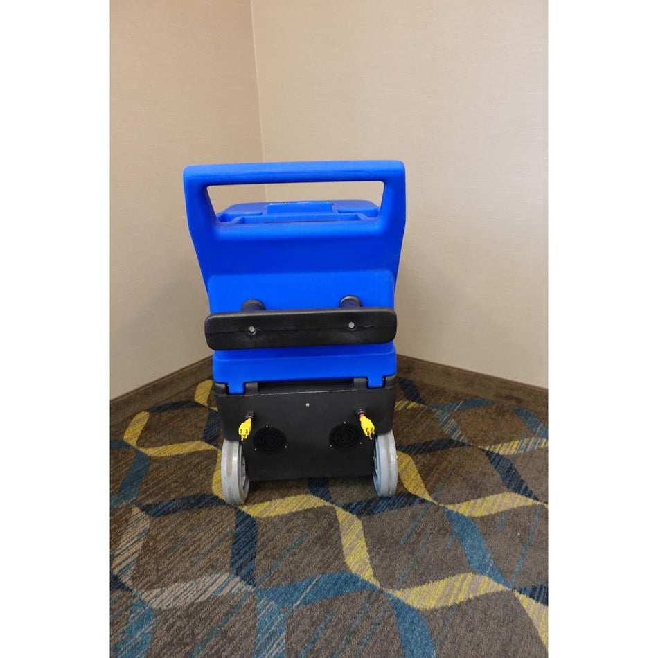 Back side view of Blue and Black U.S. Product Cobra 10.0 Carpet extractor showing big grey wheels and yellow power cord hook ups. 
