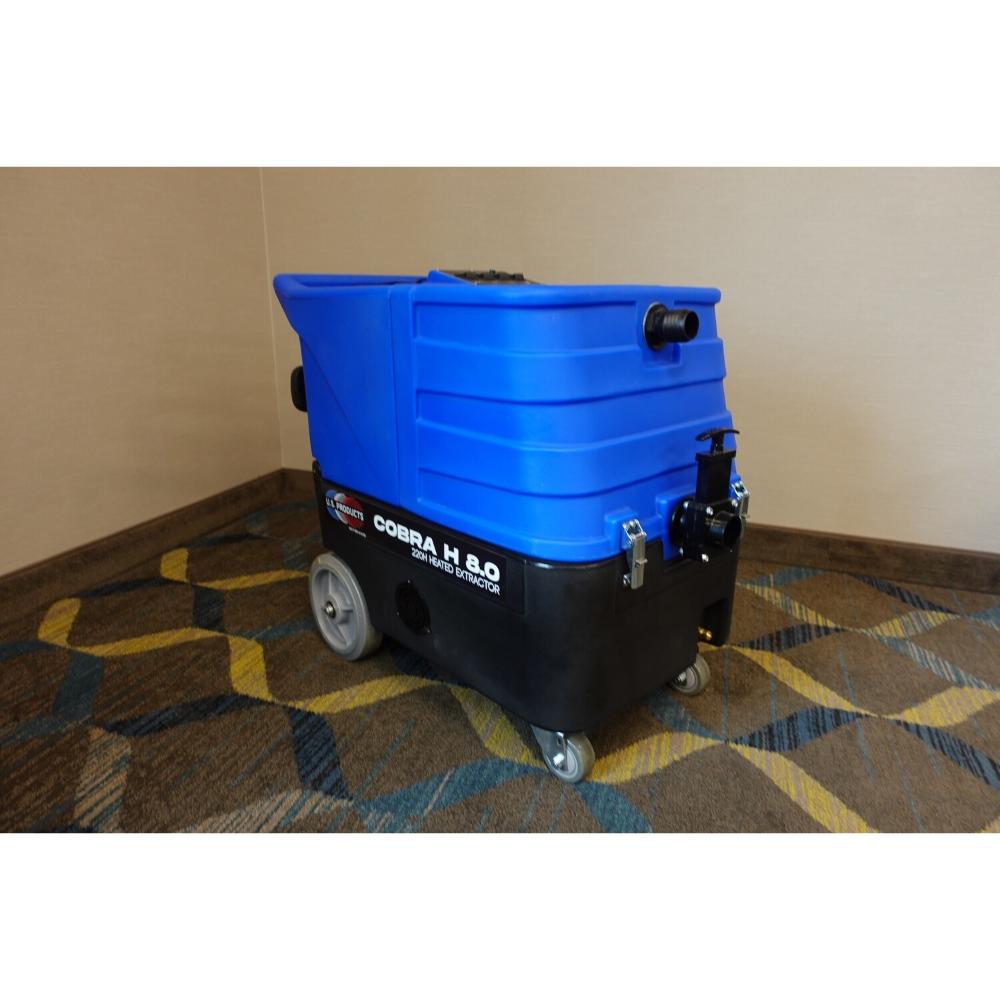 Blue top and black bottom Cobra 8.0 Carpet extractor being displayed on a multi patterned brown and yellow carpet 