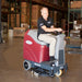 Man riding red and grey minuteman max 20 riding floor scrubber in warehouse