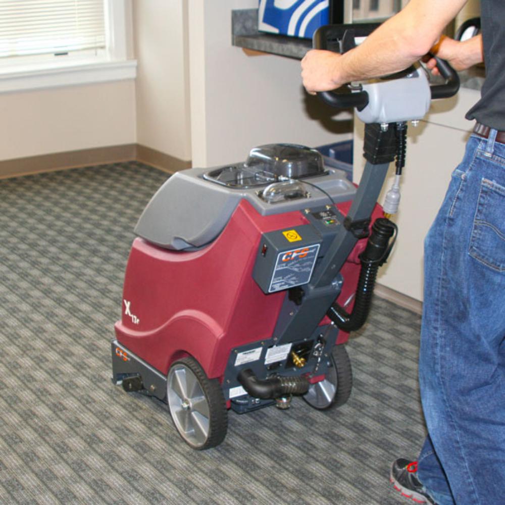 Man pushing a x-17 carpet cleaner in an office setting